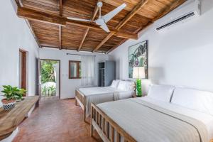 a bedroom with two beds and a ceiling fan at Nosara Beach Hotel in Nosara