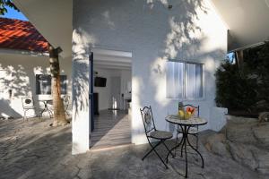 une terrasse avec une table et des chaises à côté d'une maison dans l'établissement Kata White Villas, à Kata Beach