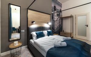 a bedroom with a large bed and a mirror at Catalog Boutique Rooms in Debrecen