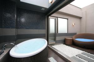 a bathroom with a tub and a toilet and a sink at HOTEL W-PREMIUM -W GROUP HOTELS and RESORTS- in Koshigaya