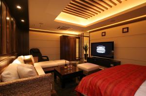 a hotel room with a bed and a flat screen tv at HOTEL W-PREMIUM -W GROUP HOTELS and RESORTS- in Koshigaya