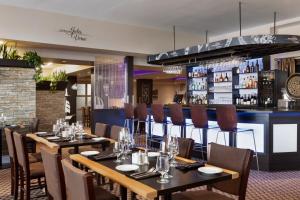 a restaurant with tables and chairs and a bar at Travelodge by Wyndham Quebec City Hotel & Convention Centre in Quebec City