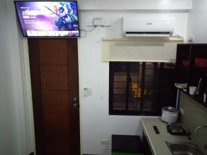 a bathroom with a tv on the wall of a kitchen at Clark-Pad Inn, Angeles City in Angeles