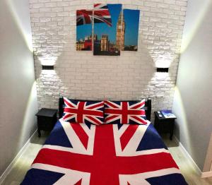 イルピンにあるApartment Studio LONDON 92のベッドルーム1室(英国旗が掲げられたベッド1台付)