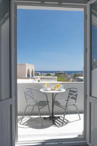 un tavolo e sedie su un balcone con vista di Join Us Low Cost Rooms a Kamari