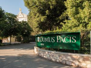 una señal verde en una valla frente a un edificio en Domus Pacis Assisi en Assisi