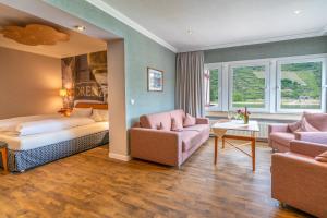 una camera d'albergo con letto e divano di Weinhotel Landsknecht a Sankt Goar