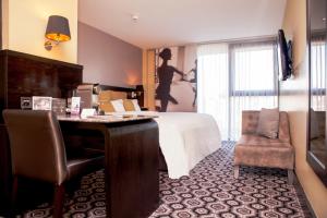 um quarto de hotel com uma cama, uma secretária e uma cadeira em The Vincent Hotel em Southport