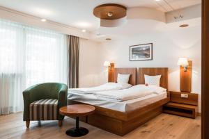 ein Hotelzimmer mit einem Bett und einem Stuhl in der Unterkunft KRONE eat drink stay in Brixen