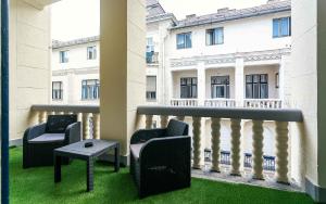 a balcony with two chairs and a table in front of a building at Catalog Boutique Rooms in Debrecen