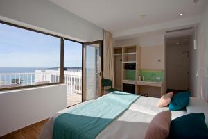 een slaapkamer met een bed en uitzicht op een balkon bij BLUESEA Anba Romaní in Cala Millor