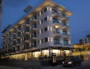 a building with a car parked in front of it at Hotel Bar Restaurant Triumf Shengjin in Shëngjin