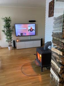 a living room with a fireplace and a flat screen tv at Askevika in Vikum