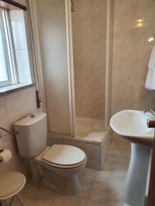 La salle de bains est pourvue de toilettes, d'une douche et d'un lavabo. dans l'établissement Hotel Novo Dia, à Mêda