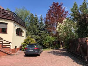 un coche aparcado en una entrada junto a una casa en Villa 37b Bed and Breakfast en Varsovia