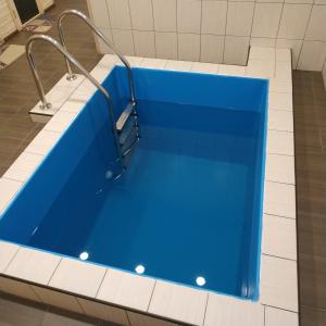 bañera azul en una habitación con azulejos blancos en Оселя Драгобрат, en Dragobrat