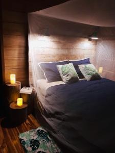 1 dormitorio con 1 cama con sábanas y almohadas azules en Poponé Farm & Lodge, en Guápiles