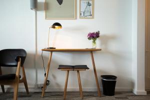 a desk with a lamp and a vase of flowers on it at Hotel Icefiord in Ilulissat