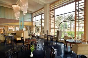 un ristorante con tavoli, sedie e finestre di InterContinental Jeddah, an IHG Hotel a Gedda