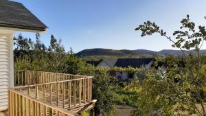 eine Holzterrasse neben einem Haus mit Bäumen in der Unterkunft Cabaña Rapel Privada in Rapel