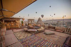 Habitación con almohadas y globos de aire caliente en el cielo en Divan Cave House en Göreme