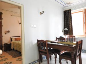 een eetkamer met een tafel en een slaapkamer bij Om Niwas Suite Hotel in Jaipur