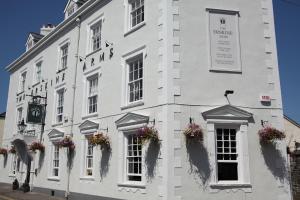 um edifício branco com caixas de flores nas janelas em The Erskine Arms em Conwy