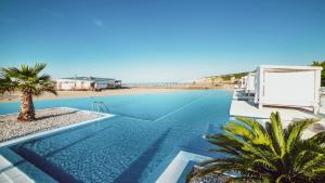ein großer Pool neben einem Strand in der Unterkunft Azul Beach Resort Montenegro by Karisma - All Inclusive in Ulcinj