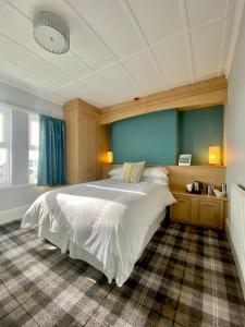 a bedroom with a large white bed and a blue wall at Cumbrian Lodge in Seascale