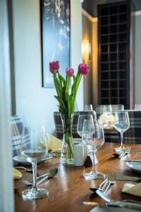 a table with pink flowers in a vase on it at Cumbrian Lodge in Seascale