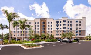 Staybridge Suites - Fort Lauderdale Airport - West, an IHG Hotel في ديفي: اعادة بناء مع موقف للسيارة