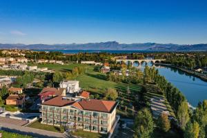 eine Luftansicht eines Resorts mit einem Fluss und einer Brücke in der Unterkunft Hotel Rivus in Peschiera del Garda