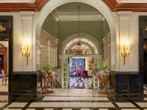 una hall con arco e fiori in vasi di The Savoy a Londra