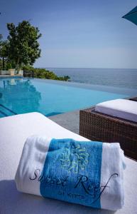 ein Handtuch auf einem Bett neben einem Pool in der Unterkunft Sunset Reef St. Kitts in Ottleyʼs