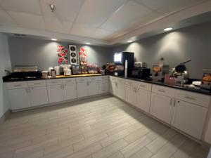 a kitchen with white cabinets and a counter top at Ramada by Wyndham Luling in Luling