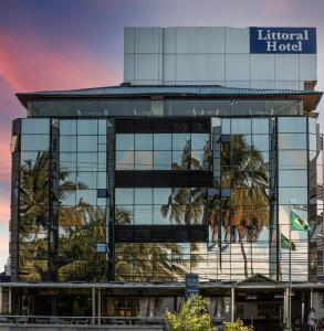 un edificio con un riflesso di palme nelle finestre di Littoral Hotel a João Pessoa