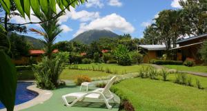 a resort with a chair and a mountain in the background at Catarata Eco Lodge in Fortuna