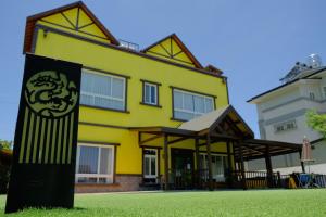 a yellow house with a sign in front of it at Puli Diary in Puli