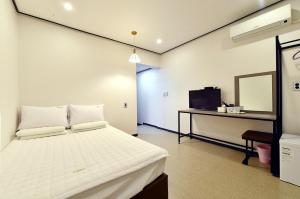 a bedroom with a bed and a desk and a television at Casa Mini Hotel in Gyeongju