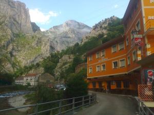 una calle frente a una montaña con un edificio en Hostal Poncebos, en Poncebos