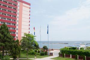 ein Gebäude mit zwei Flaggen vor dem Meer in der Unterkunft Hotel Paradiso in Mangalia