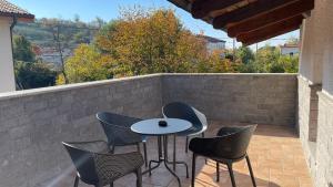 un patio con mesa, sillas y pared en MADONCA ROOMS & RESTAURANT, en Nova Gorica