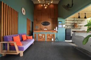 ein Wohnzimmer mit einem lila Sofa und einem Kamin in der Unterkunft Tea Tree Boutique Resort in Rawai Beach