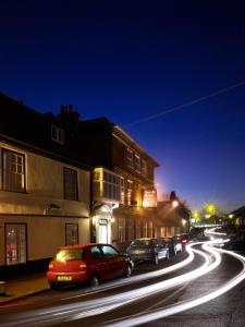 eine Stadtstraße in der Nacht mit auf der Straße geparkt in der Unterkunft The Boleyn Hotel in Staines