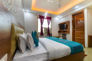 a bedroom with a large bed and a television at Hotel Urban Tree At Delhi Airport in New Delhi