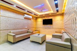 a waiting room with couches and a flat screen tv at Hotel Urban Tree At Delhi Airport in New Delhi