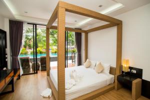 - une chambre avec un lit blanc et une vue sur la piscine dans l'établissement Z&Z House, à Rawai Beach