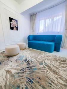 sala de estar con sofá azul y alfombra en Unique Hotel Apartments Iasi en Iaşi