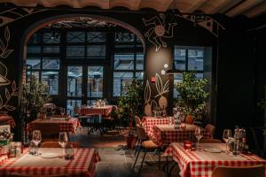 un restaurante con mesas con manteles rojos y blancos en Hotel Saint-Amour en Durbuy