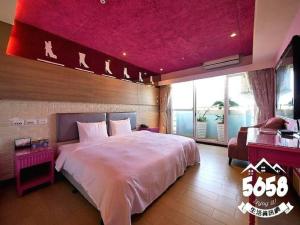 um quarto com uma cama grande e um tecto rosa em R8 Eco Hotel em Kaohsiung